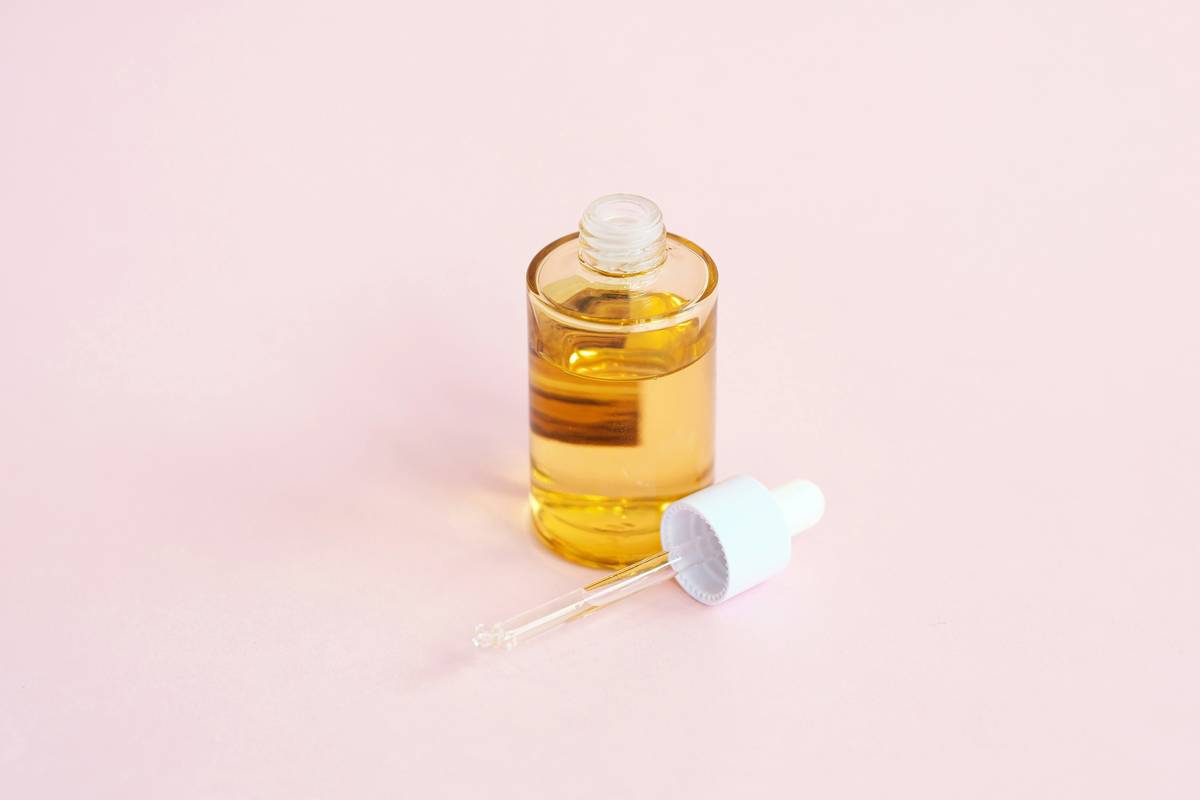 Close-up of witch hazel toner applied with cotton pad to cheek showing faded red post-acne marks — witch hazel for acne scars